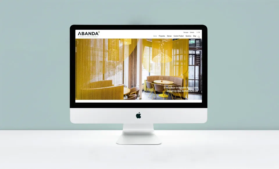 Web de Abanda en un iMac con la foto de un interior con cortinas de cuentas amarillas
