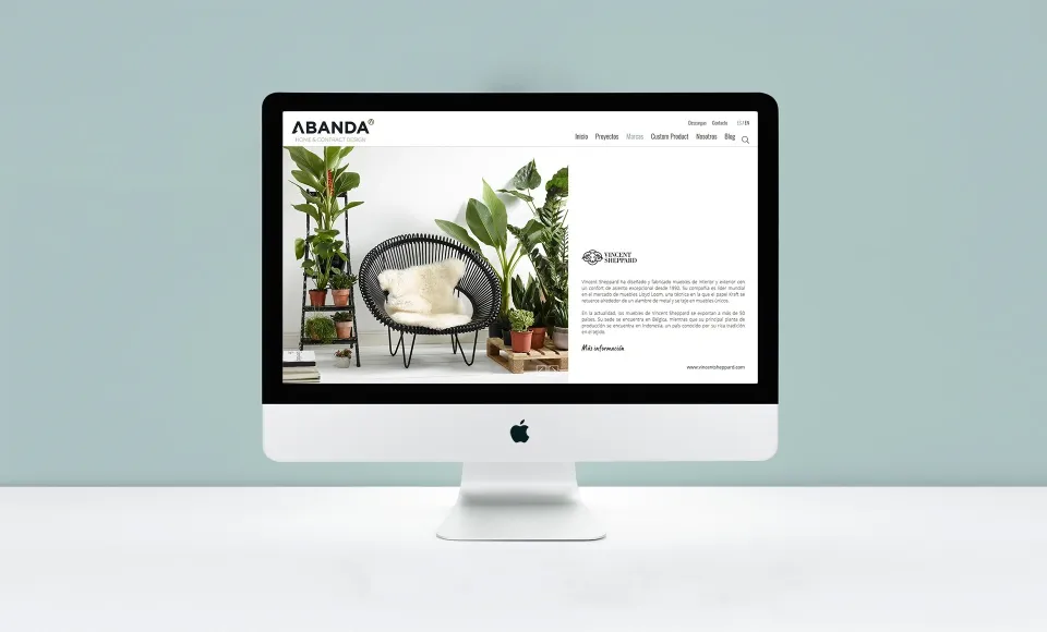 Web de Abanda en un iMac con la ficha de una silla circular negra entre plantas