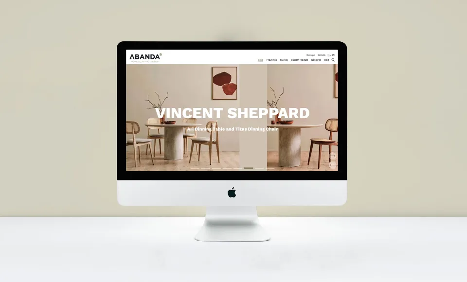 Web de Abanda en un iMac con la cabecera «Vincent Sheppard» y una mesa redonda con sillas