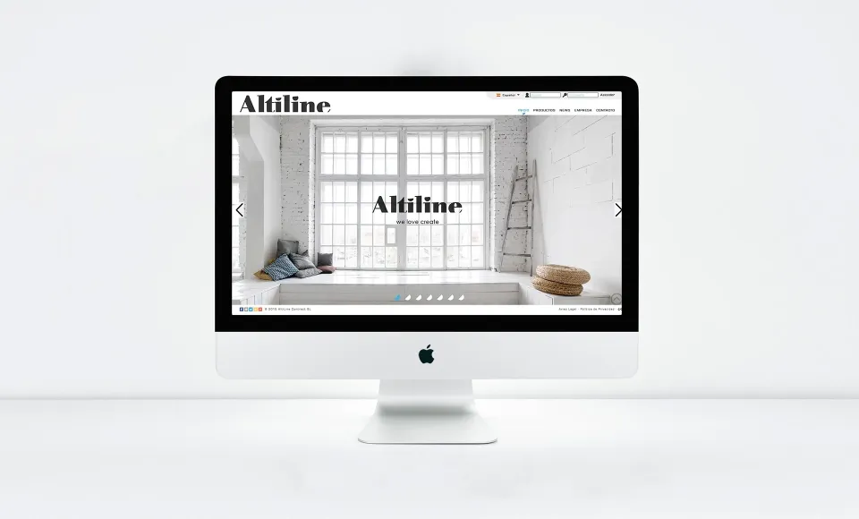 Web de Altiline en un iMac con la página de inicio y una escalera de madera en un loft blanco