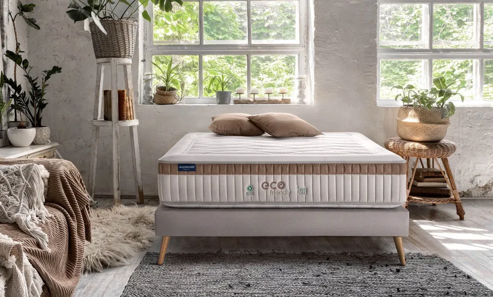 Bright bedroom with plants at the windows and an eco-friendly Dormitienda mattress