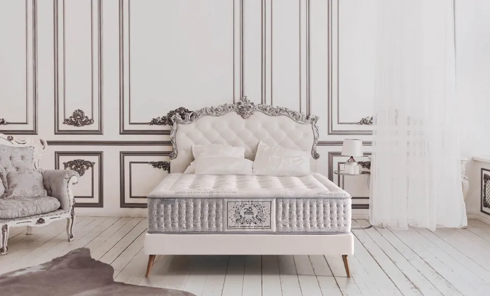 Classic French-style bedroom with a silver upholstered headboard and an embroidered mattress