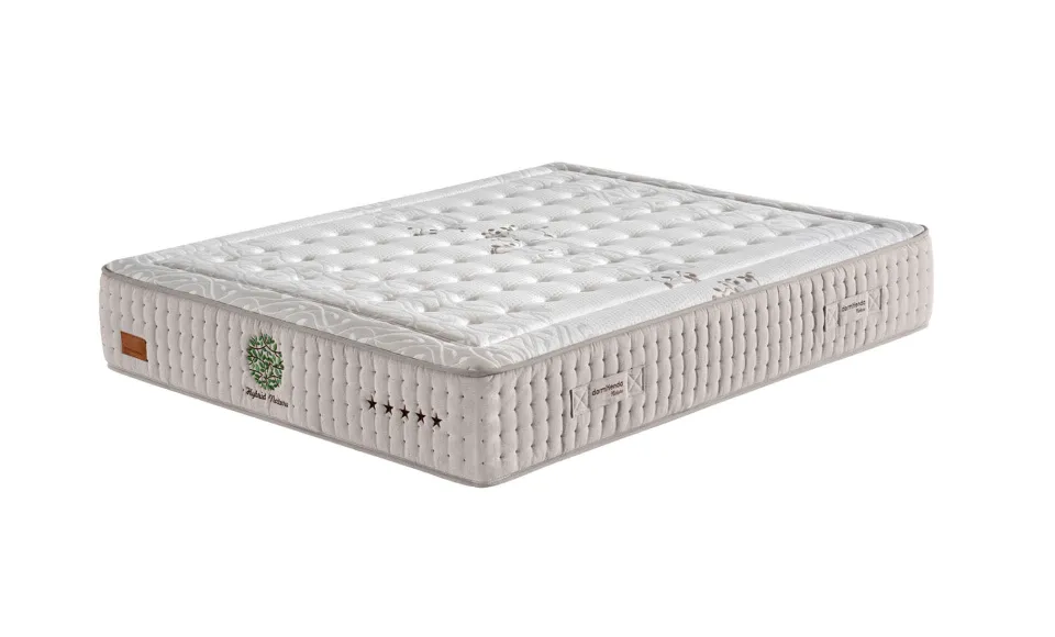 Beige quilted mattress shown at an angle with a quality label