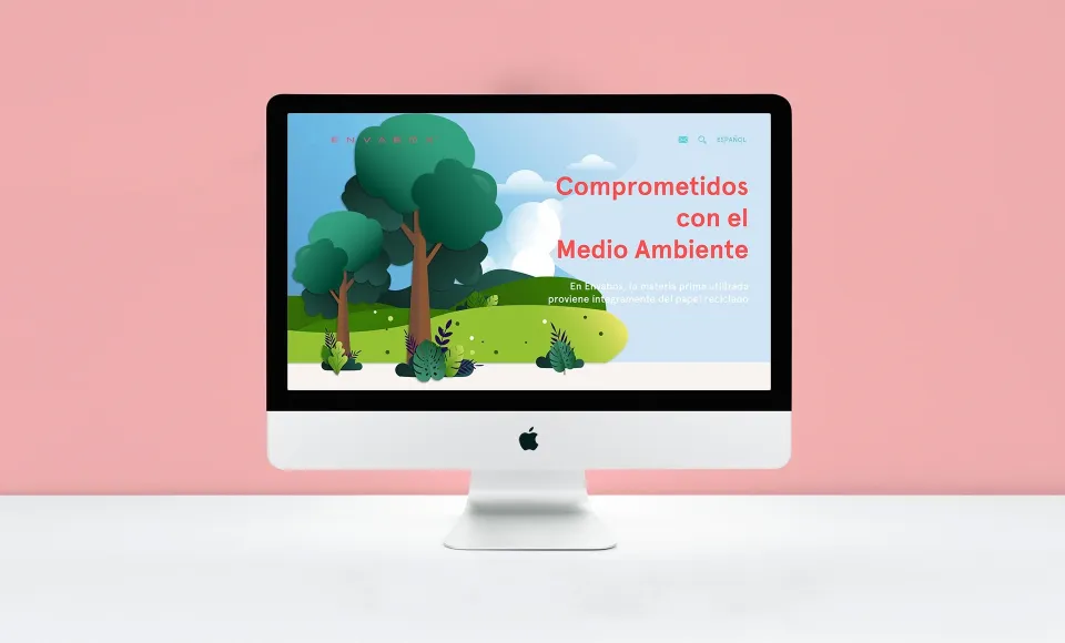 Ordenador de sobremesa sobre fondo rosa con una ilustración de árboles en la web de Envabox