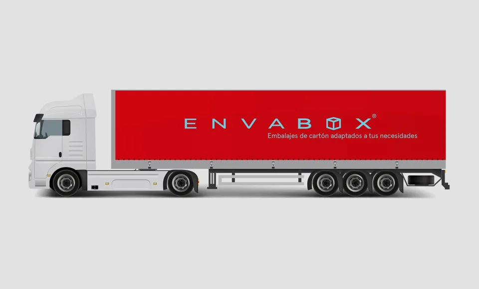 Otra vista lateral del camión de Envabox con la lona roja rotulada y el remolque de tres ejes