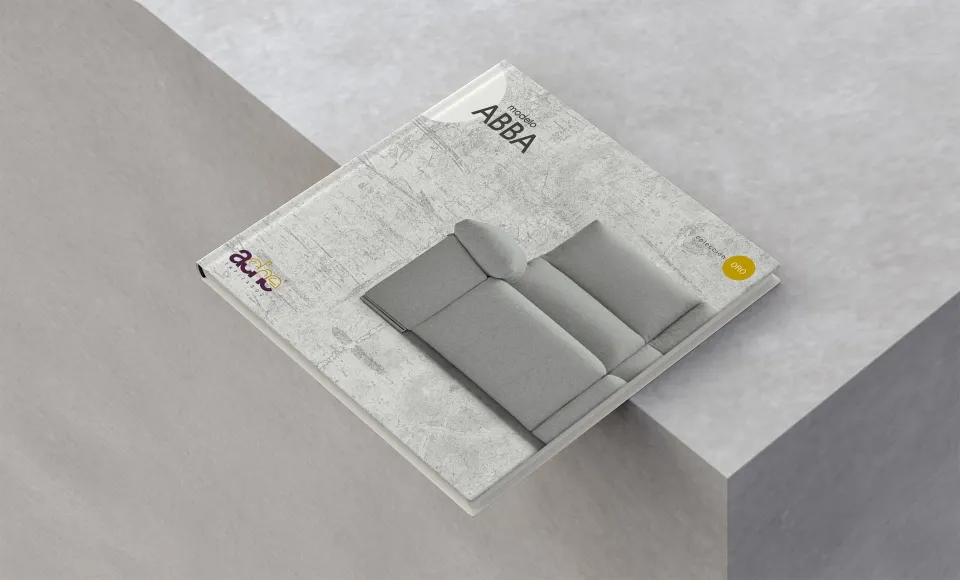 Catálogo cerrado del modelo Abba con textura de hormigón y el sofá gris en la portada