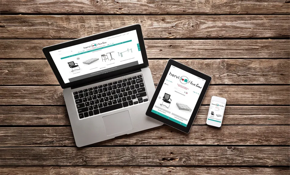 Portátil, tablet y móvil sobre madera mostrando la tienda online de Hervi