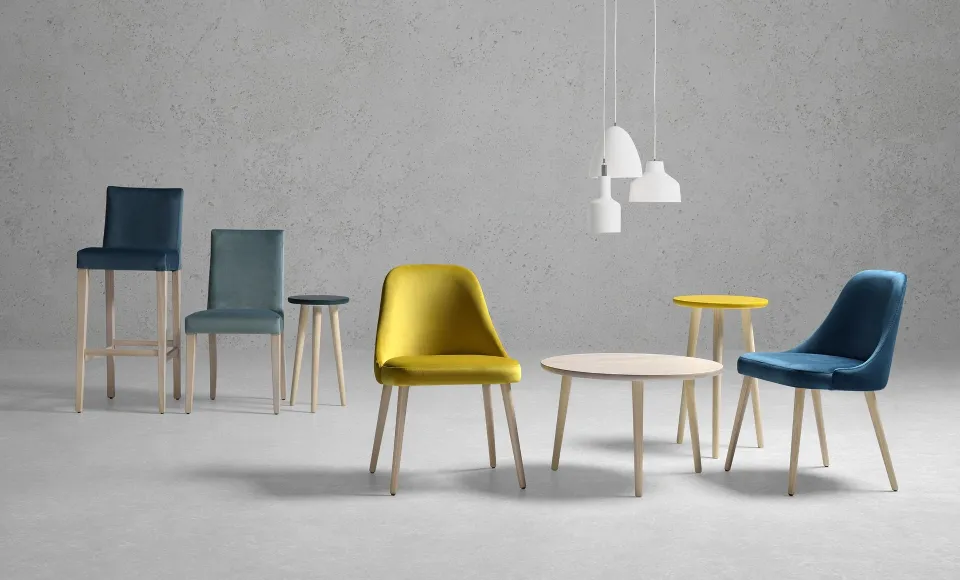 A set of chairs and stools in different colours with a round table and pendant lights