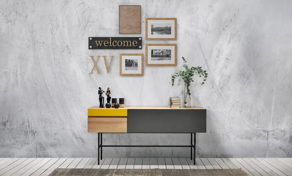 Yellow-and-grey sideboard unit with framed pictures and decorative letters on the wall