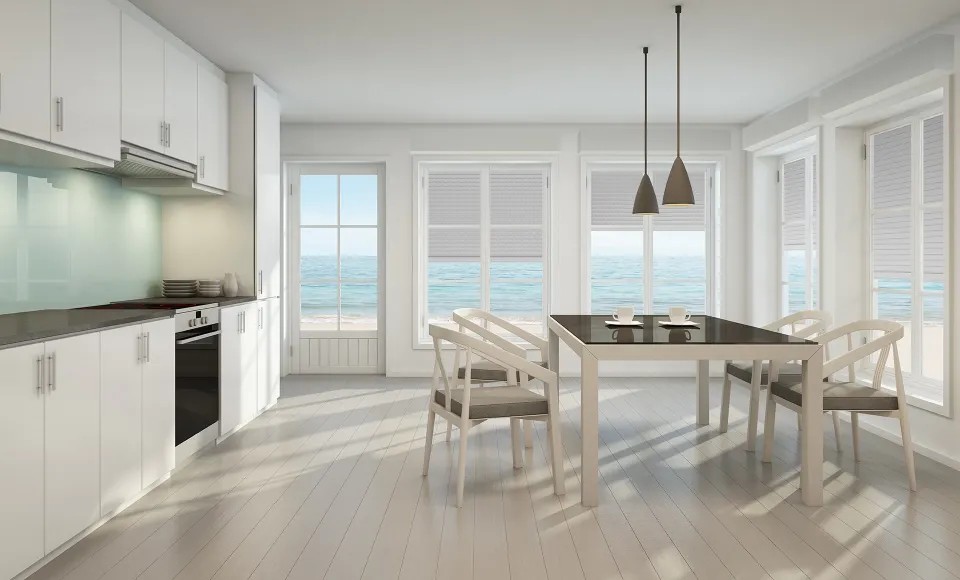White kitchen and dining area with venetian blinds and sea views