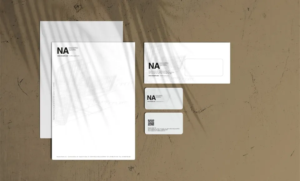 Navarro Azorín's letterhead, envelope and business cards laid out on a textured surface with leaf shadows