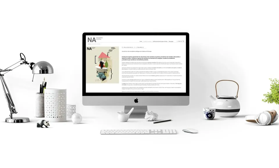 Web de Navarro Azorín abierta en un iMac sobre un escritorio con lámpara y tetera