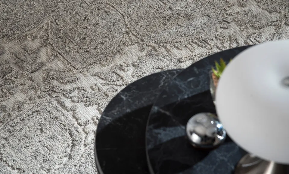Alfombra texturizada crema con bandejas de mármol negro de Parentesi Quadra
