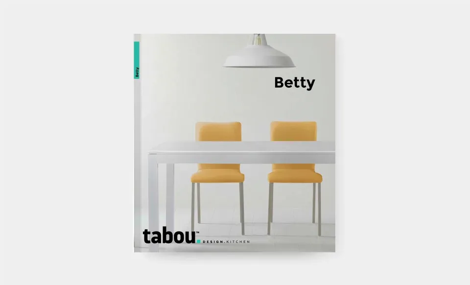 Portada del catálogo Betty de Tabou con una mesa blanca y sillas amarillas bajo una lámpara