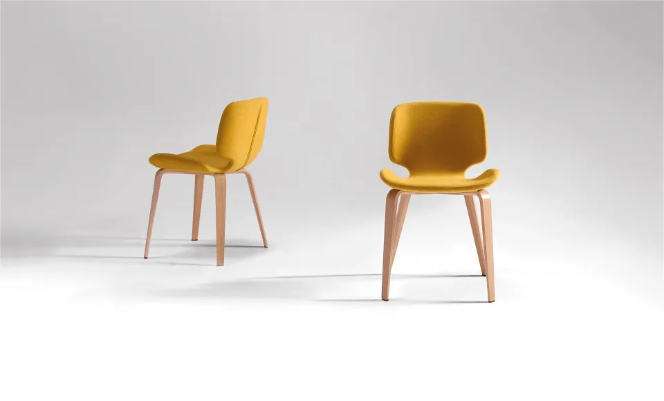 Dos sillas tapizadas en amarillo mostaza con patas de madera, mostradas desde dos ángulos