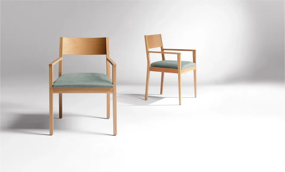 Two wooden armchairs with sage-green upholstered seats, shown from two angles