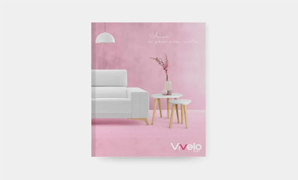 Portada rosa del catálogo de Vívelo con un sofá y unas mesas auxiliares blancas