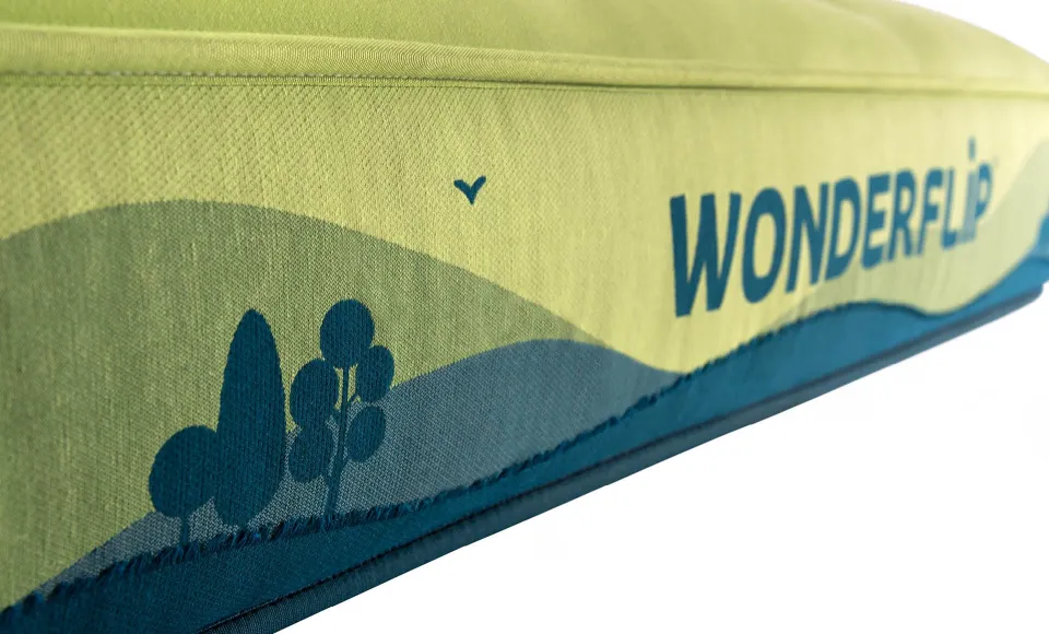 Close-up of the Wonderflip mattress corner showing an illustrated tree print